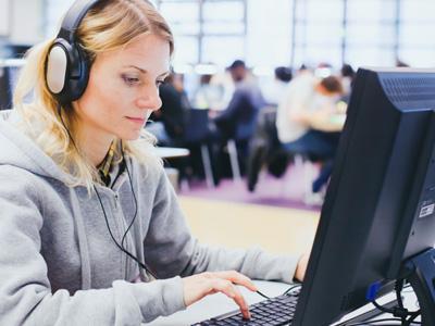 woman at computer with headphones